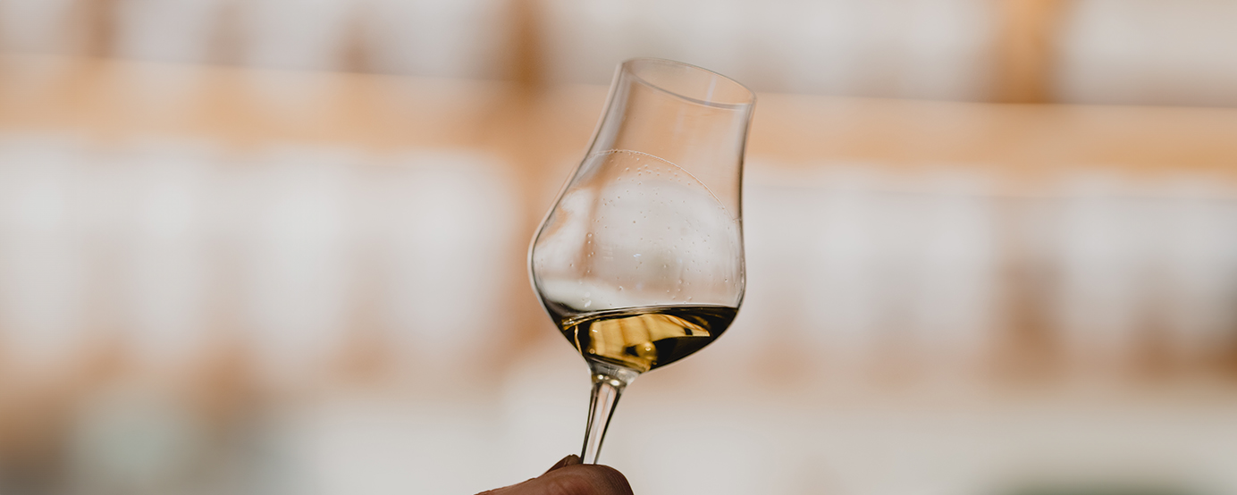 A person holding a glass of whisky