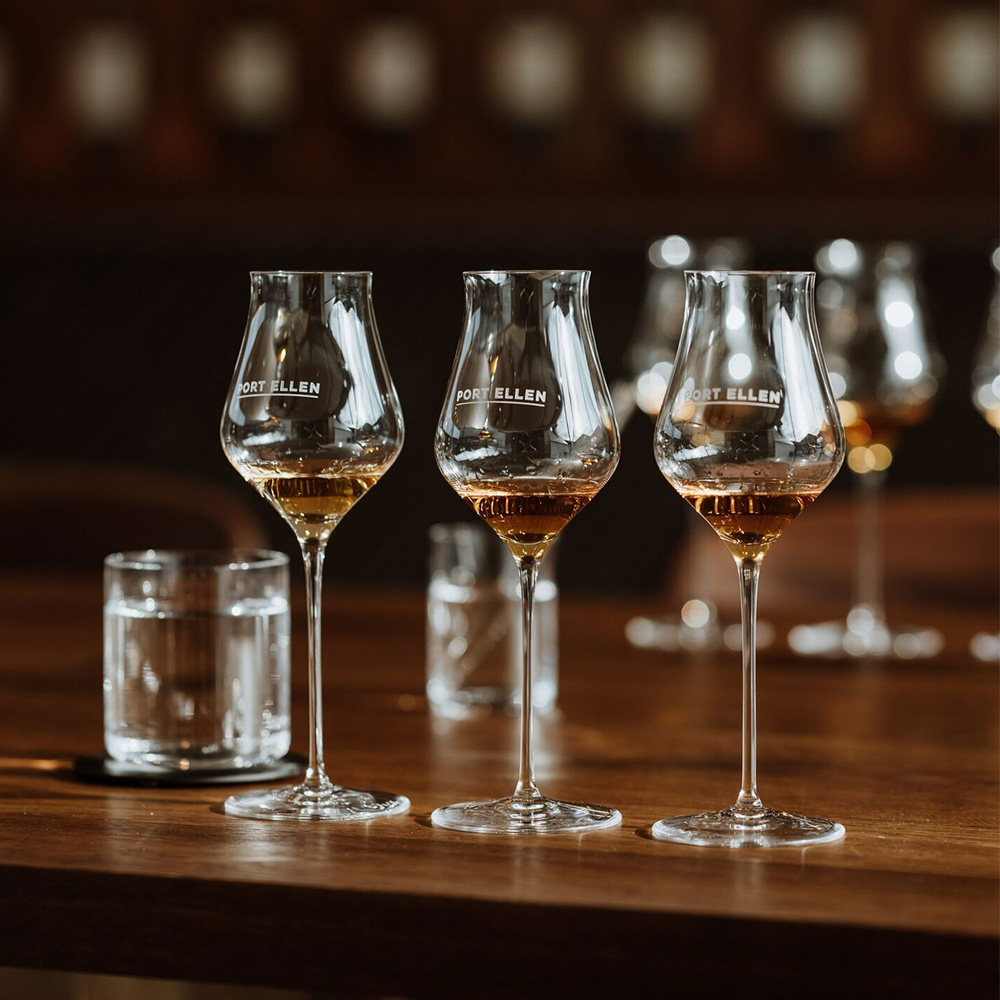 Three glasses of Port Ellen whisky on a wooden table