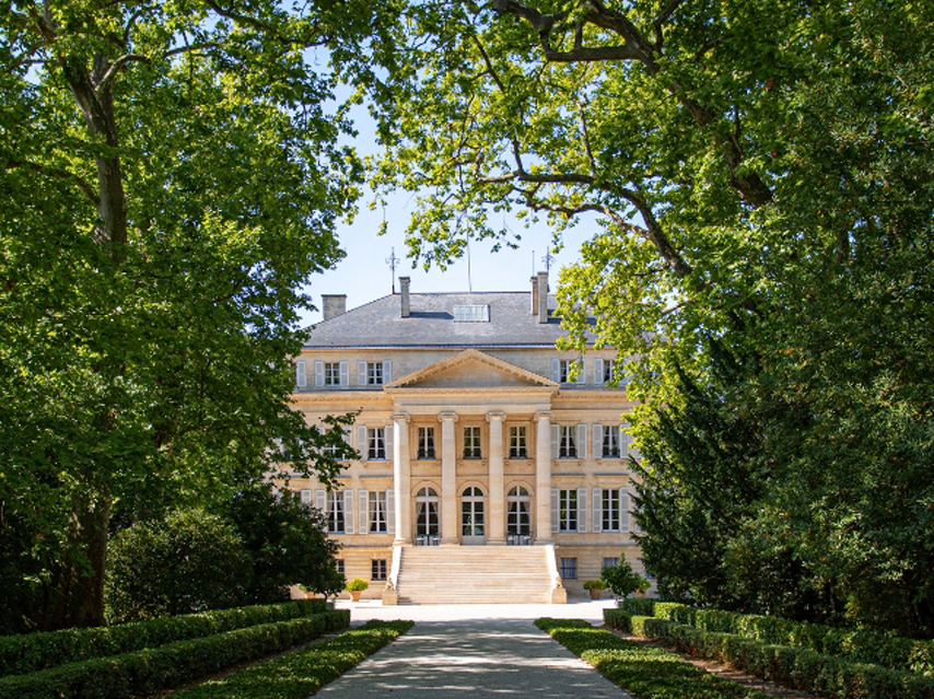 Grand building with columns through the trees, MARGAUX