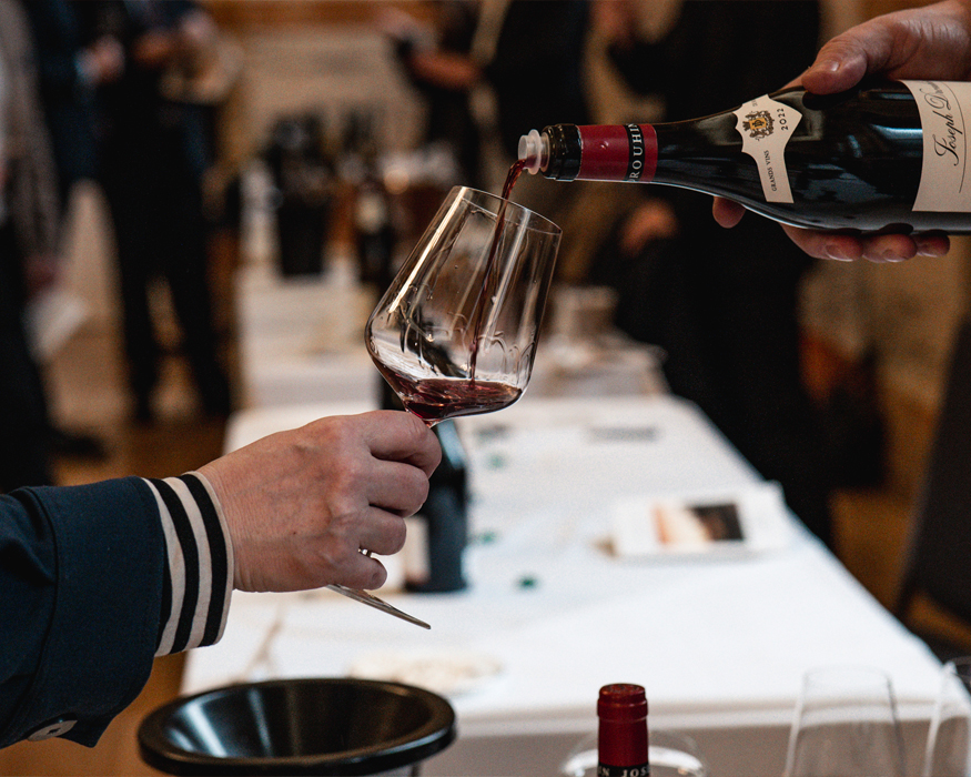 A glass being filled with red wine