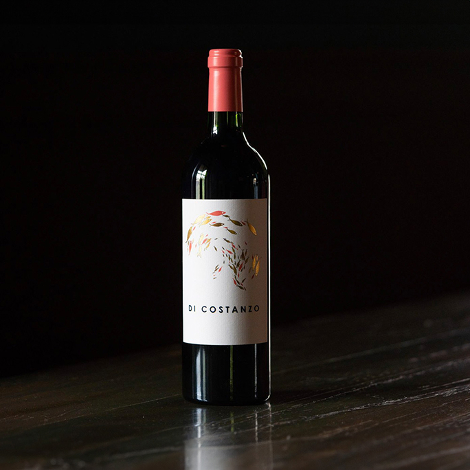 A bottle in Diconstanzo on a table in a dark room