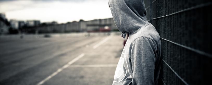 Youth wearing hoodie looking away into distance 