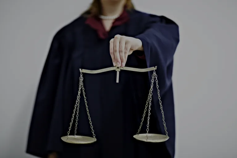 Person in robes holding scales of justice