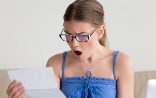 Woman gasping looking at piece of paper