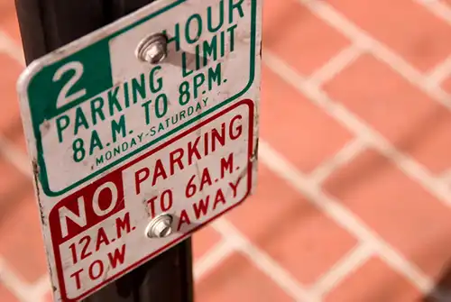 Closeup of a street sign with parking restrictions