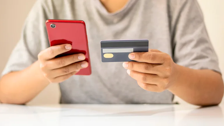 Person holding phone and credit card