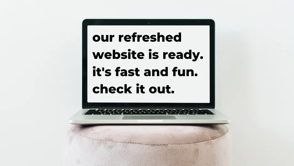 Laptop positioned on a stool, with words on screen about refreshed website