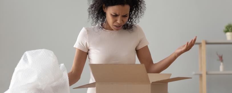Woman opening a box looking unhappy