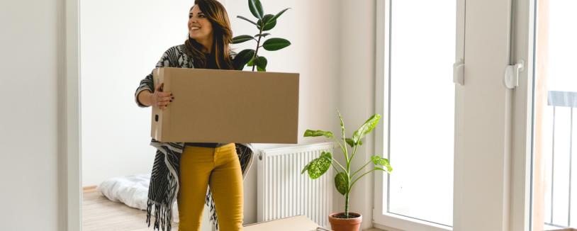 Couple moving boxes into empty room