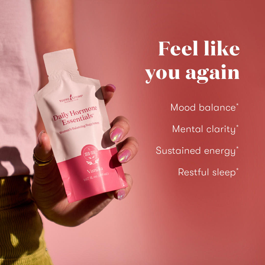 Close-up of a person in casual clothing holding a Daily Hormone Essentials pouch against a rose-toned background. Accompanying text lists perceived benefits: mood balance, mental clarity, sustained energy, and restful sleep.