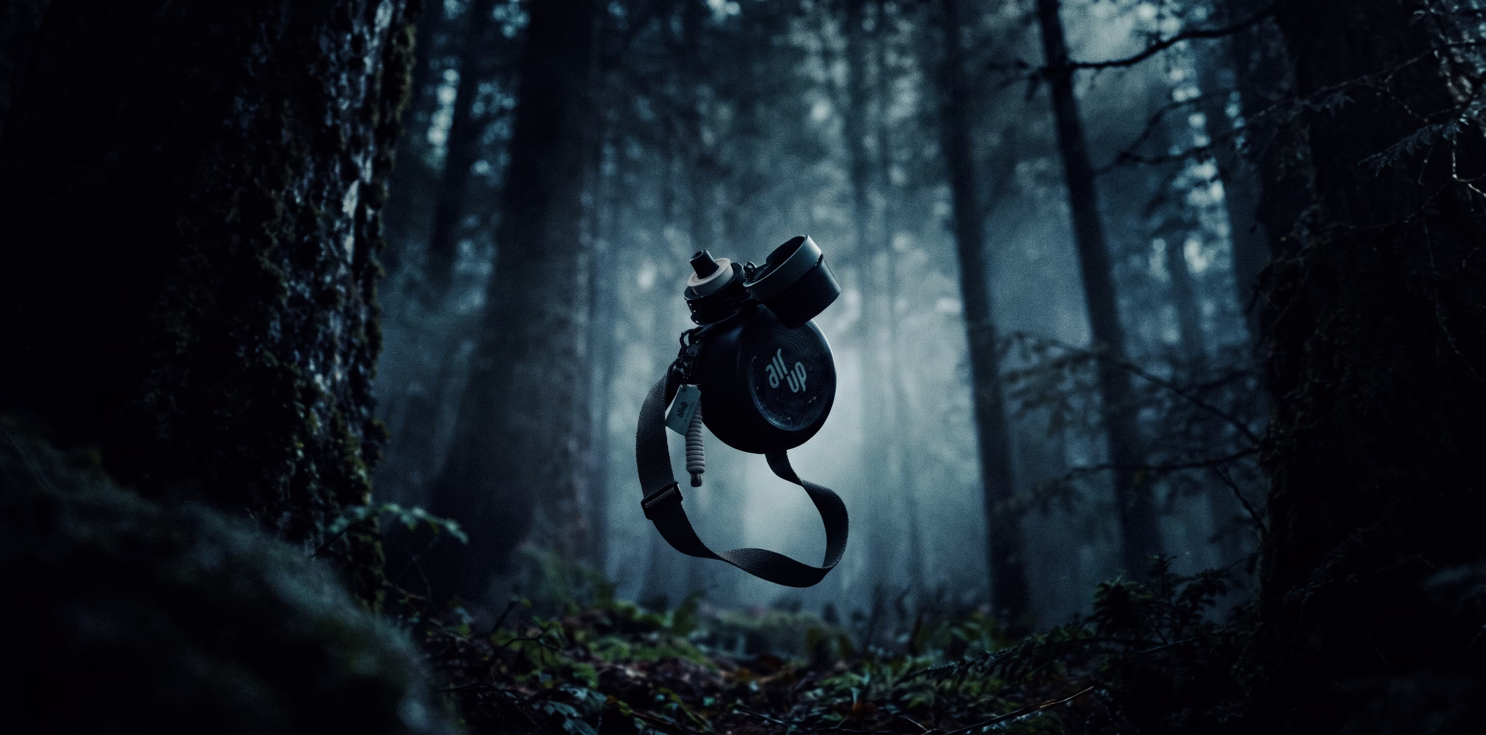 The air up x Inoxtag bottle with its strap floating in a dark, misty forest