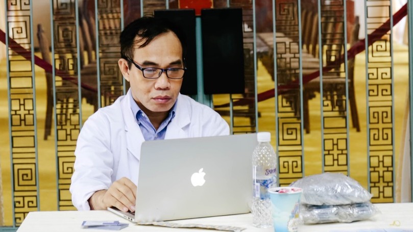 Man in white coat on laptop