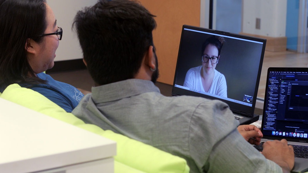 Yash and Stella sit at a couch and video chat with Sarah