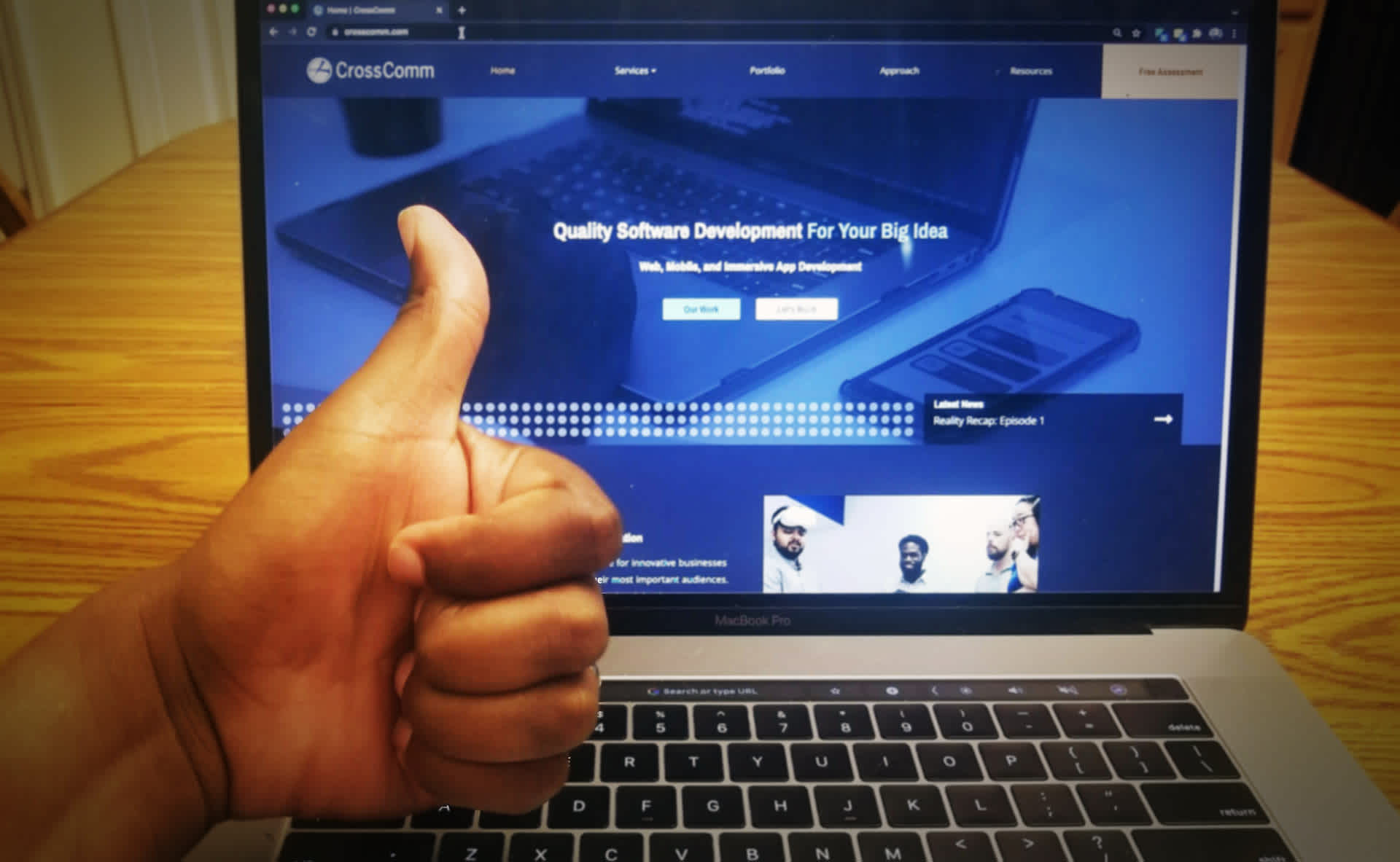 Thumbs up in front of lap top with new website loaded