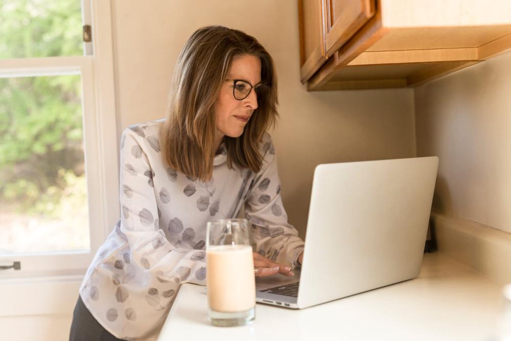 woman working on laptop from kitchen