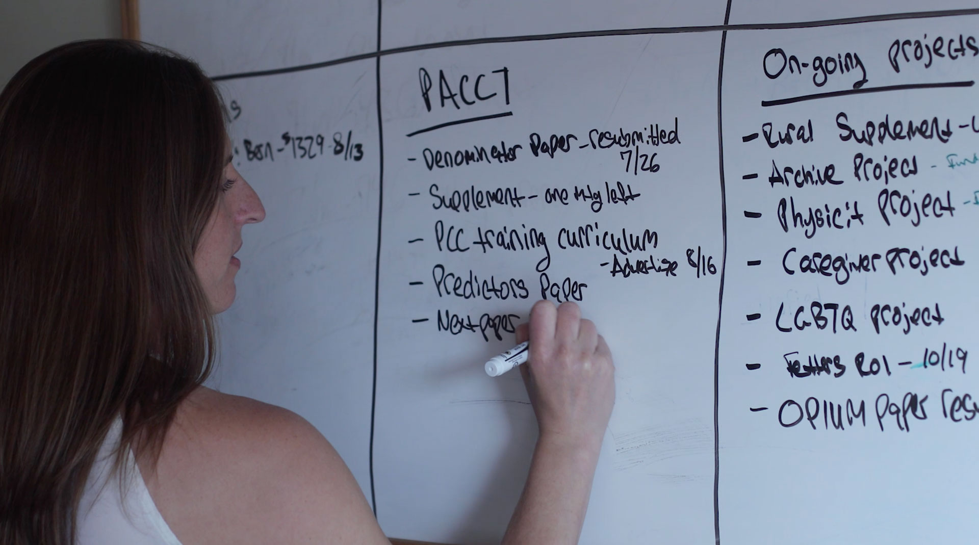 A researcher outlines plans for a research mobile application on a whiteboard