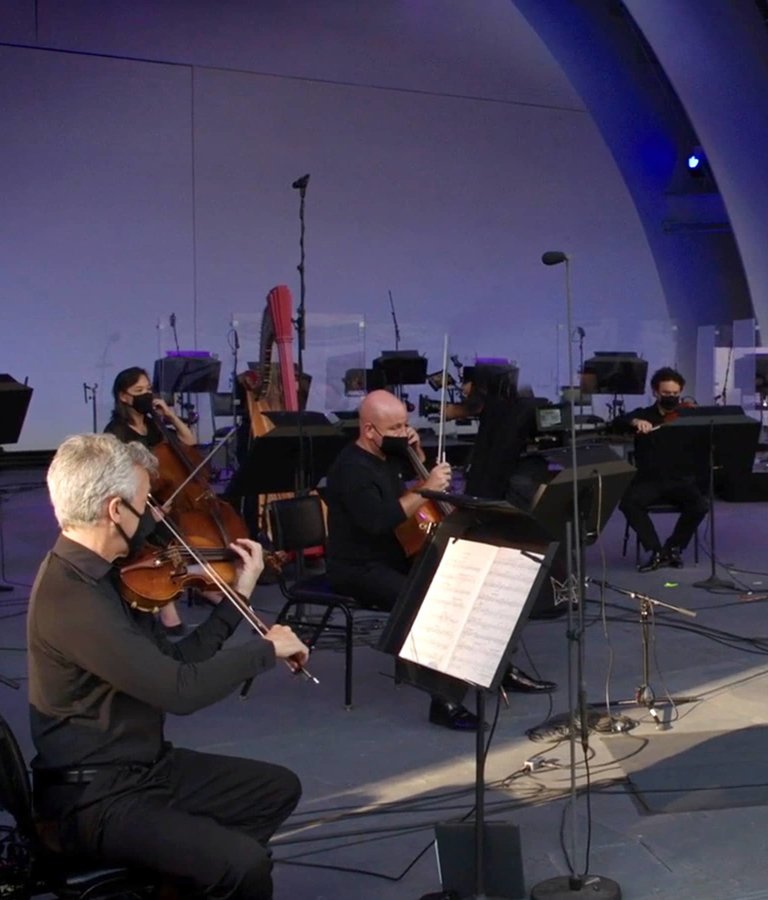 The Los Angeles Philharmonic on the stage of the Hollywood Bowl, conducted by Gustavo Dudamel.