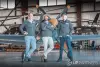 Three men standing in front of small airplane
