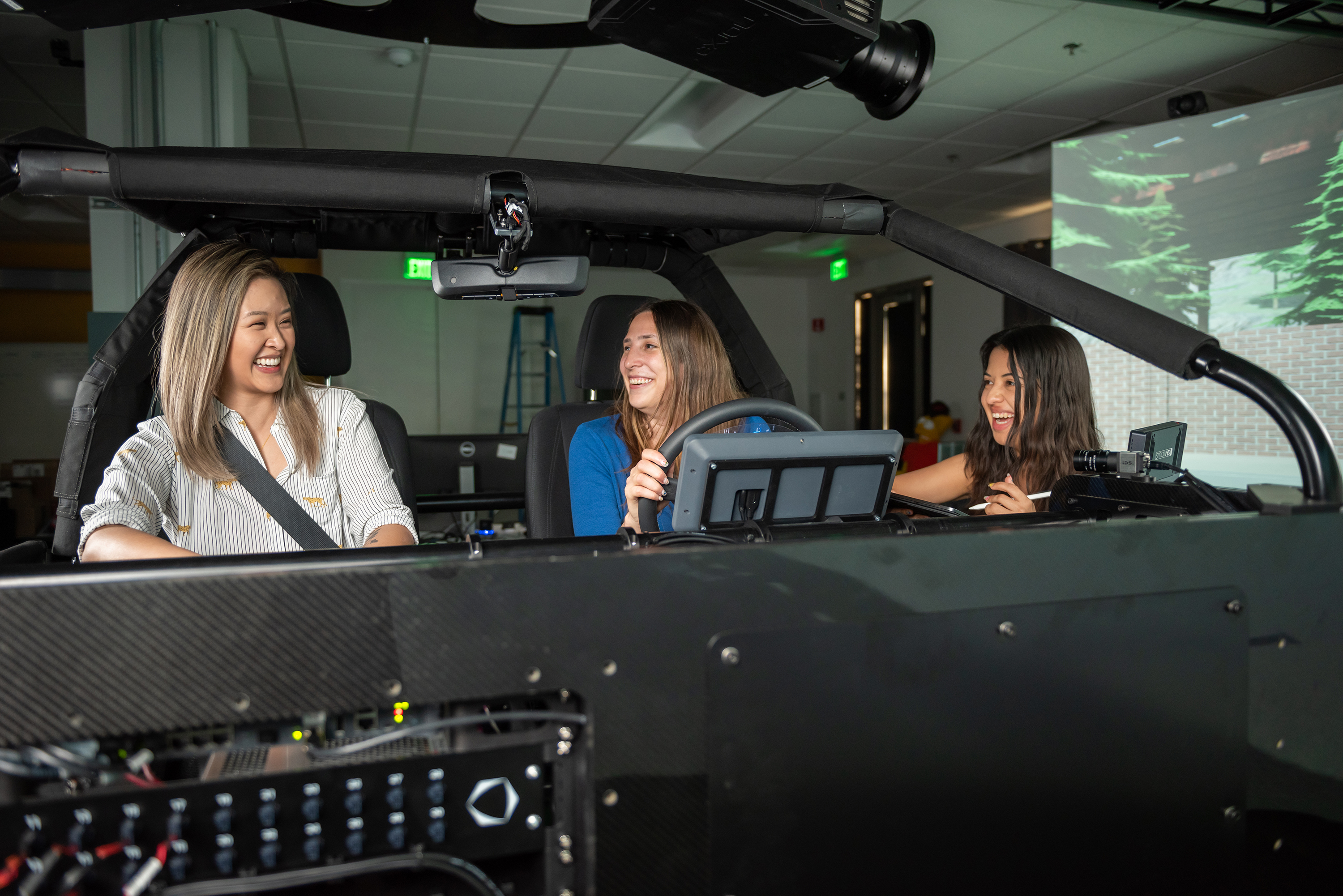 Two women sitting in a driving simulator.