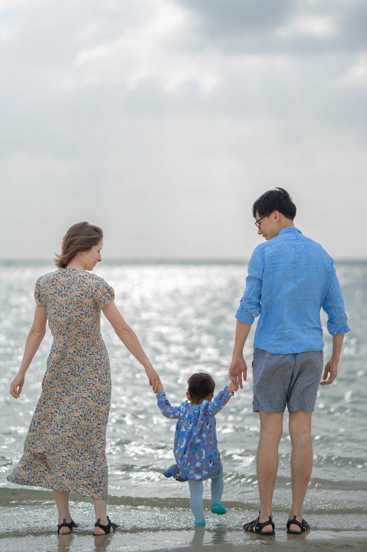 家族と一緒に砂浜を歩くハンナ