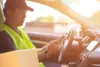 Deliveryman on his smartphone in car