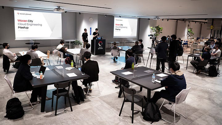 Group of people attending a meetup event held at Woven by Toyota, sitting through a presentation