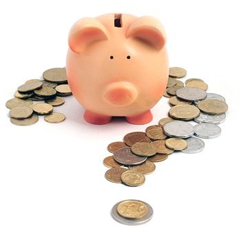 A question mark made from coins, with a piggybank in the centre.