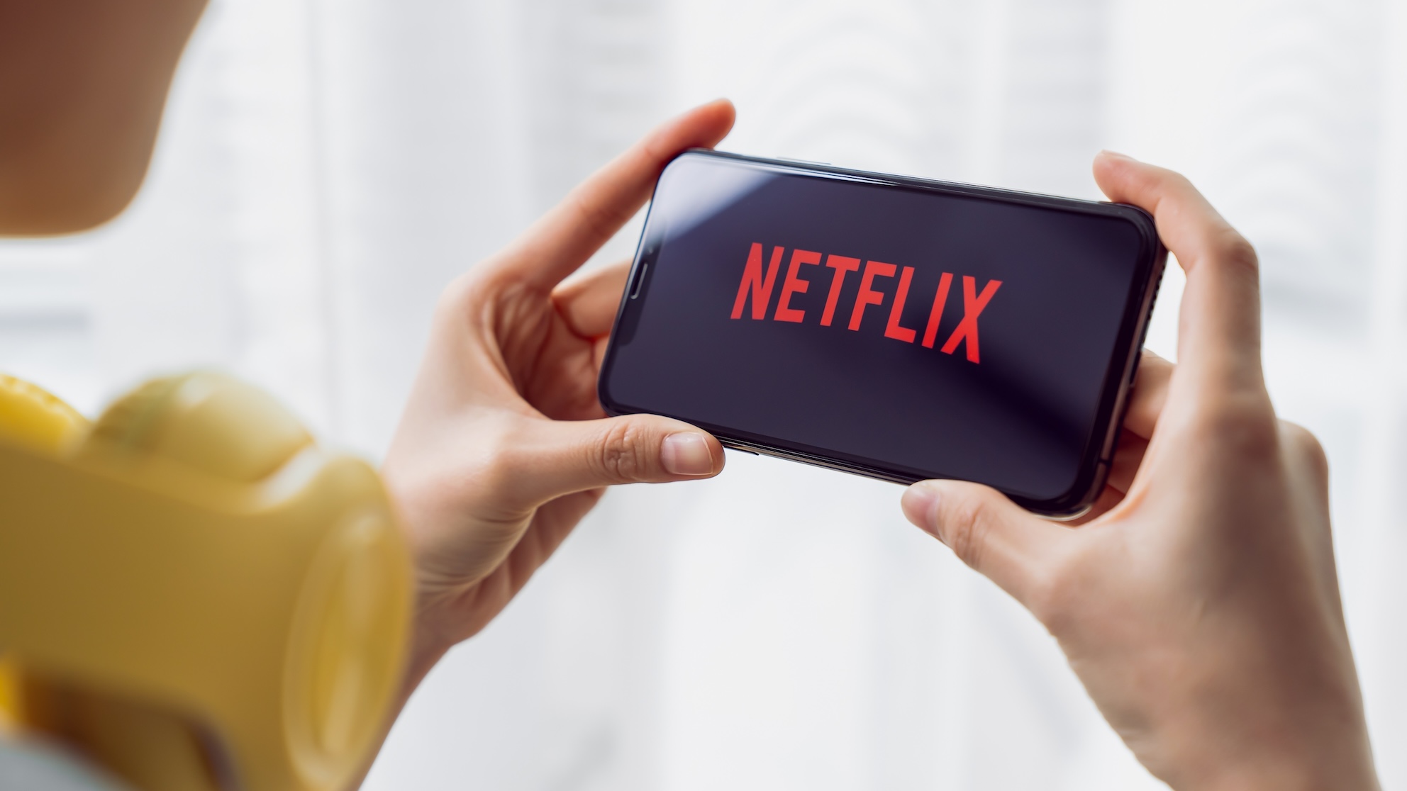 A woman watching Netflix on her phone.