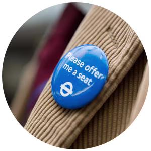 A blue 'Please offer me a seat' badge with the TfL roundel.