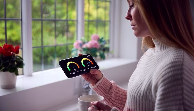 A woman looking at her smart meter.