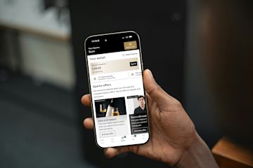 A person holding a phone that shows offers on the M&S app