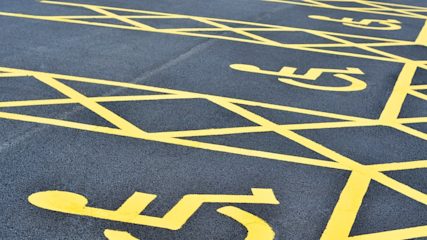 Rows of yellow-lined disabled parking spaces in a car park.