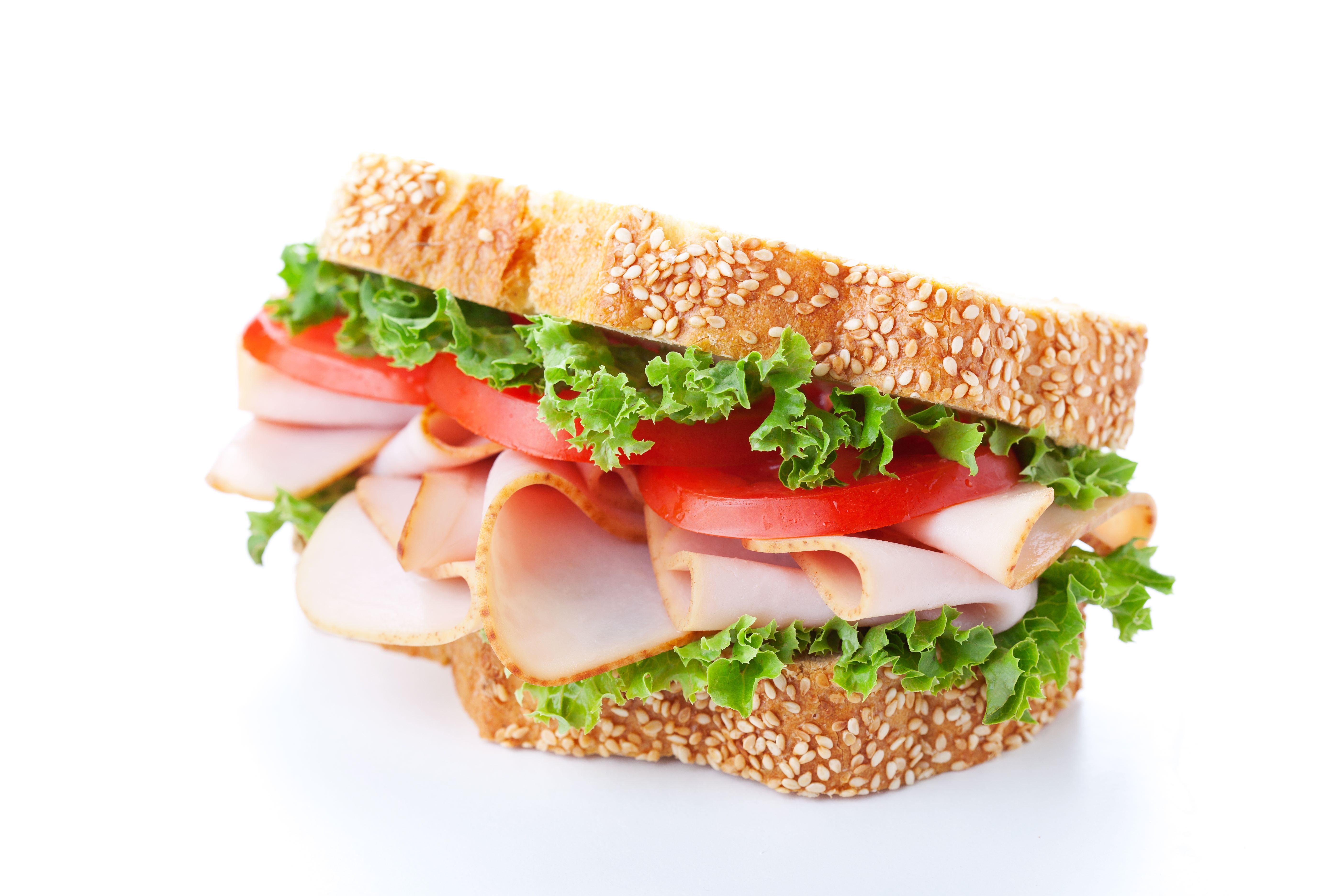 A chicken, lettuce and tomato sandwich with a sesame seed crust.