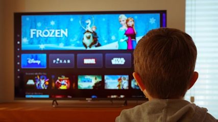 Image showing small child watching Disney+ on the TV screen.