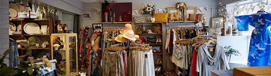 Image shows a charity shop with a range of clothes that look vintage