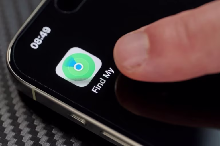 A finger goes to select the 'Find My' app on a mobile phone screen.
