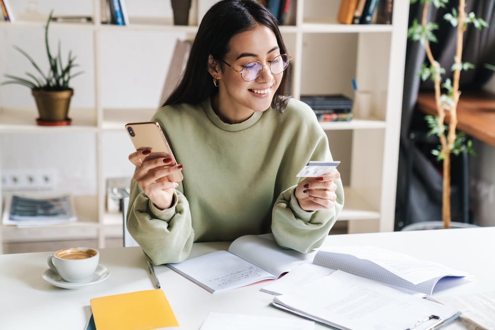 Woman smiling with smartphone and credit card