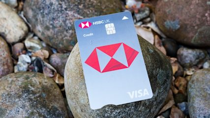 HSBC UK Visa credit card set against background of beach pebbles