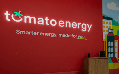 Tomato Energy logo on a wall with the statement 'Smarter energy, made for you.'