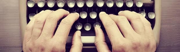 Fingers typing on a typewriter