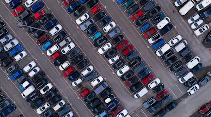 Image shows an aerial view of a car park filled with cars