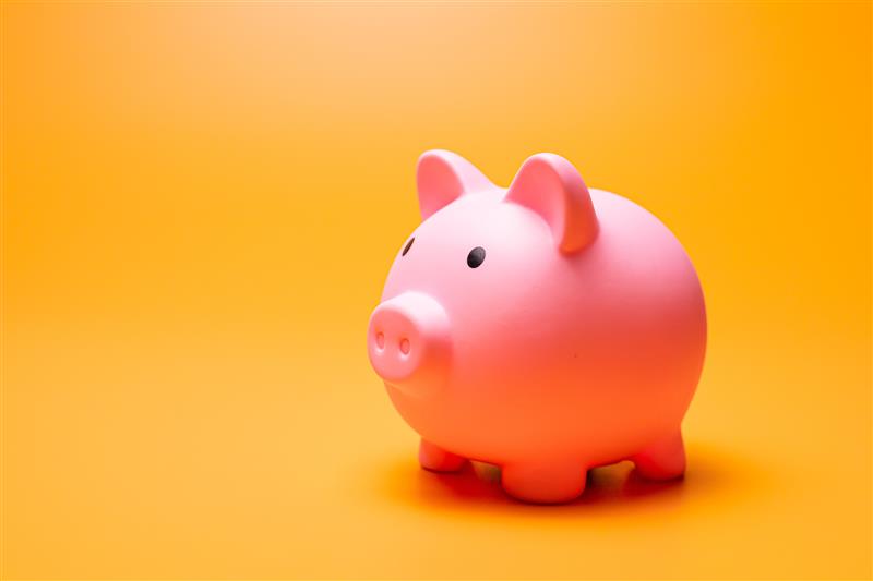 A pink piggy bank against a bright yellow background