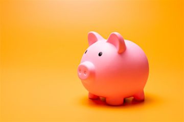 A pink piggy bank against a bright yellow background