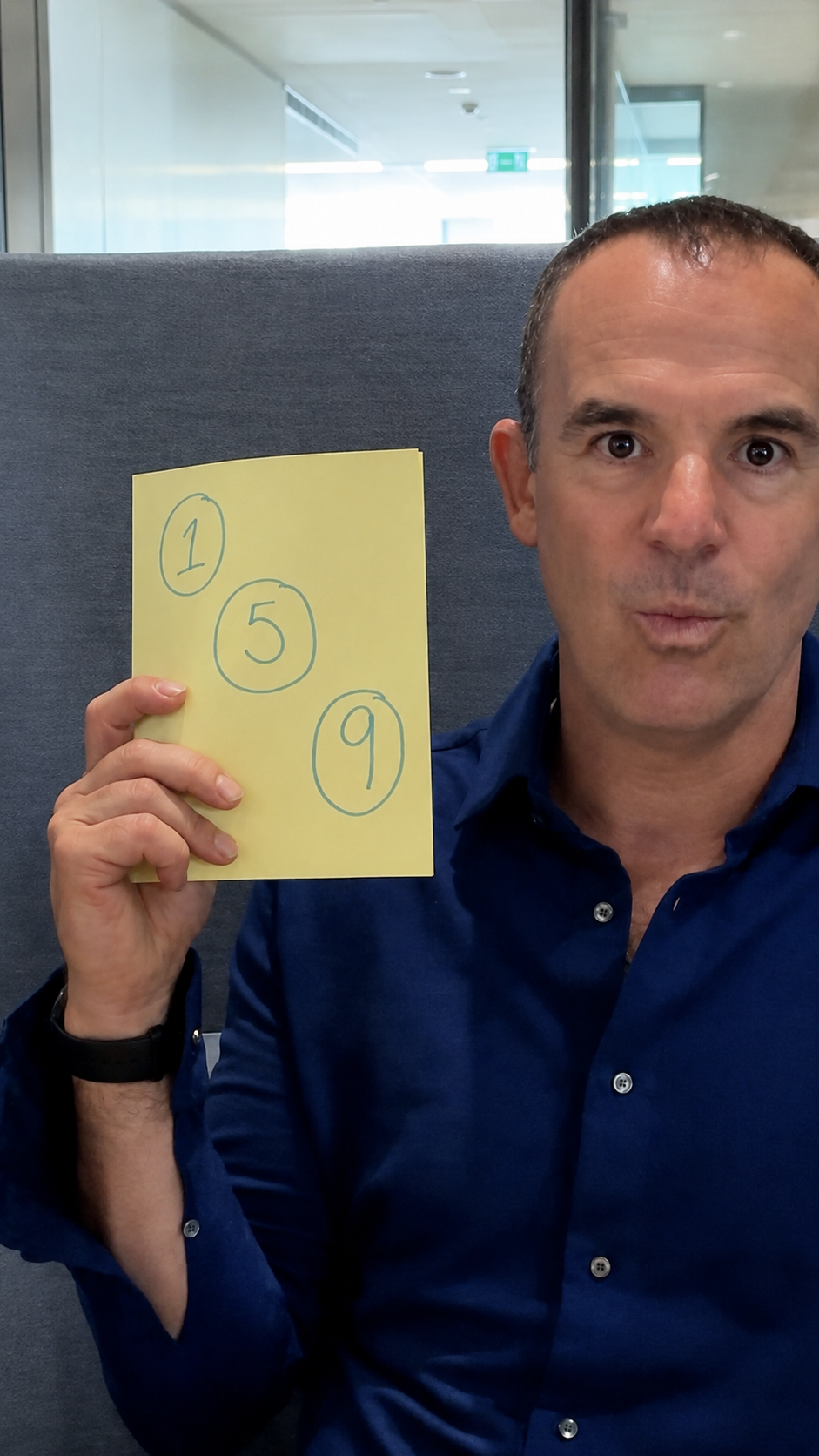 Martin Lewis holding a piece of paper with the numbers 159 written on it.