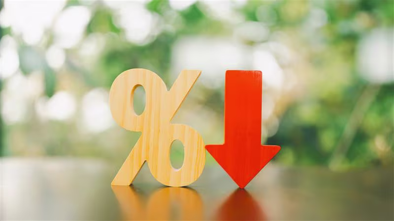 A wooden percentage block with a bright red downwards arrow