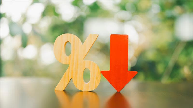 A wooden percentage block with a bright red downwards arrow