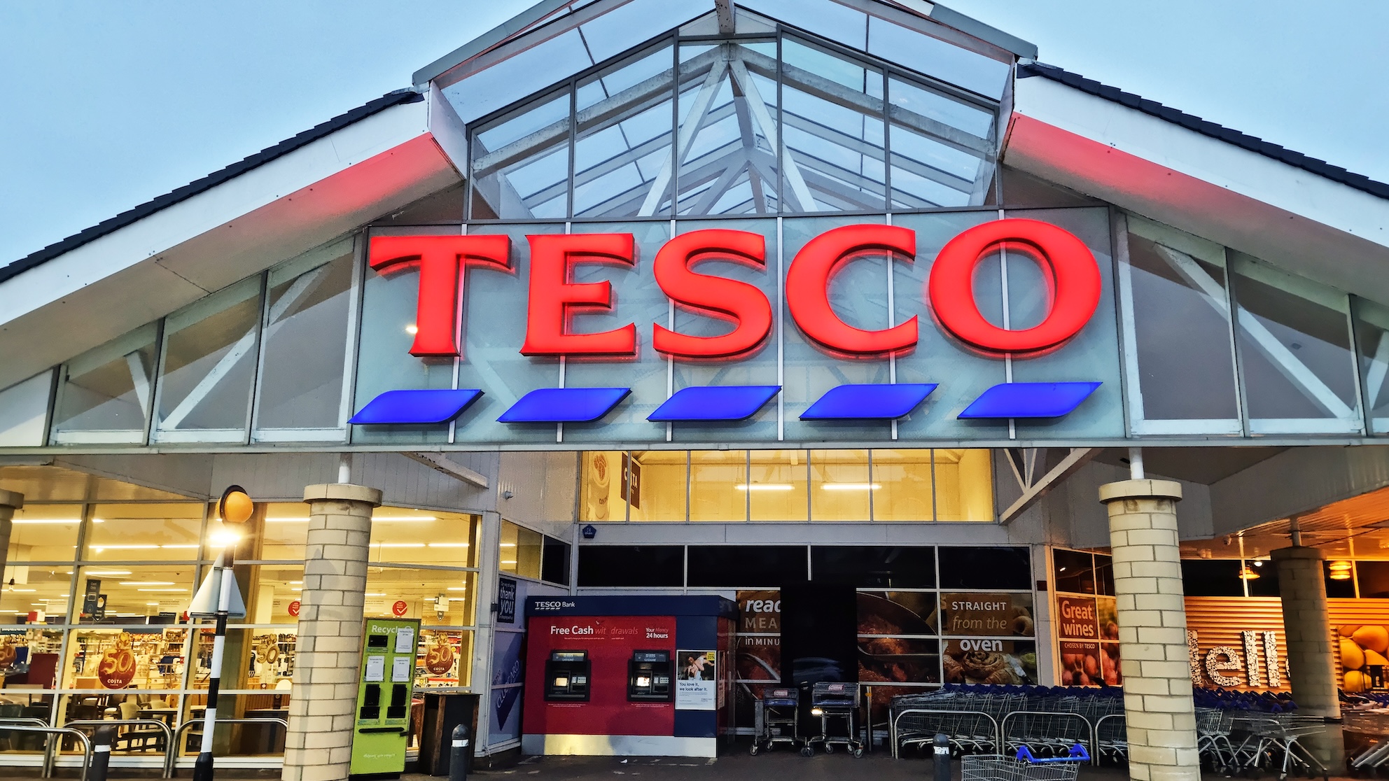 A Tesco storefront with a pointed roof and large glass windows