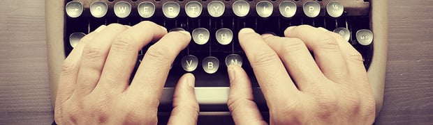 fingers typing on typewriter
