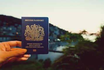 Image shows a hand holding a British passport
