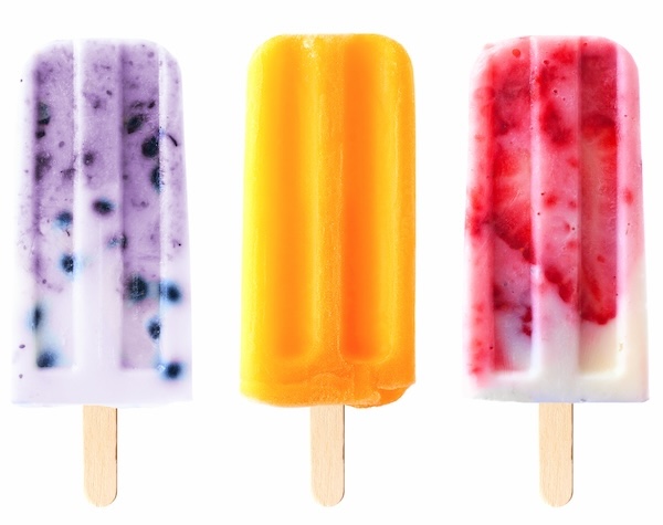 Three fruit ice lollies stood upright